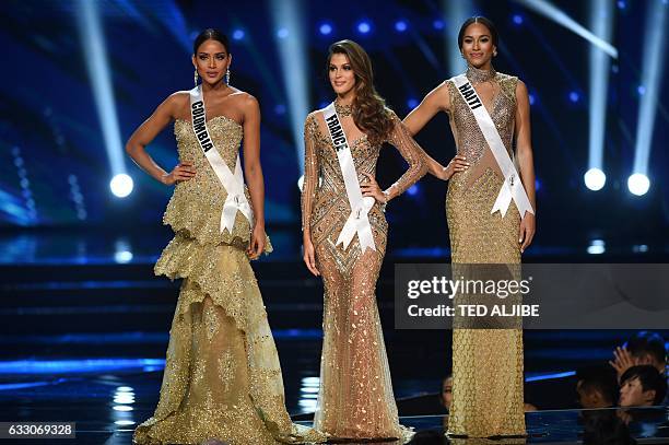 Miss Universe candidates Andrea Tovar of Colombia, Iris Mittenaere of France and Raquel Pelissier of Haiti stand on stage as they wait for the...