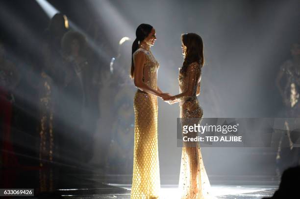 Miss Universe candidate Iris Mittenaere of France holds hands with Raquel Pelissier of Haiti prior to the announcement of the winner during the...