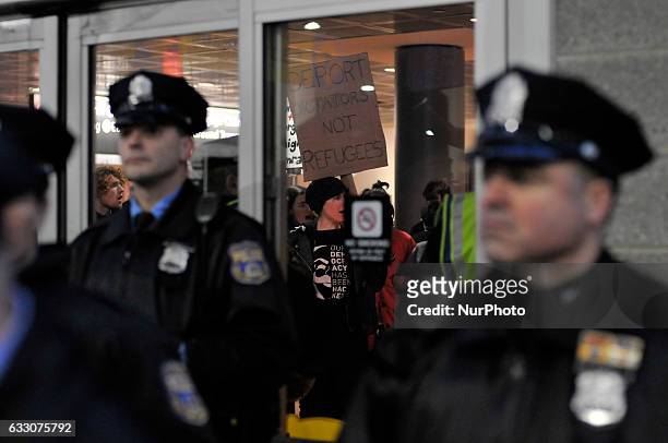 Police stand by at the doors as a small group of protestors occupies a space inside as thousands turn out for a January 29th, 2017 Immigration Ban...