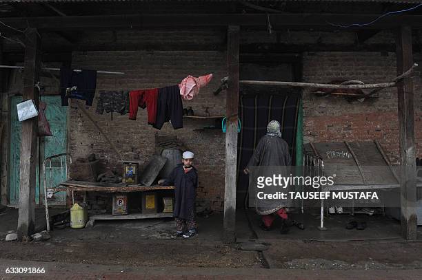 Relatives of a leprosy patient stand outside a mud house at the leprosy hospital in downtown Srinagar on January 30, 2017. World Leprosy Day is...