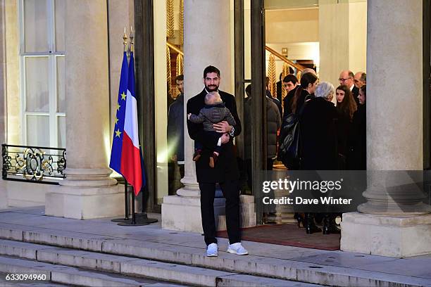 Nikola Karabatic of the France handball team, who have just won the World Championships, holds his son Alek as he arrives to meet with French...