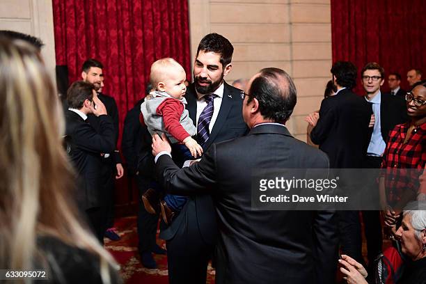 Nikola Karabatic of the France handball team, who have just won the World Championships, presents his son Alek to French president Francois Hollande...