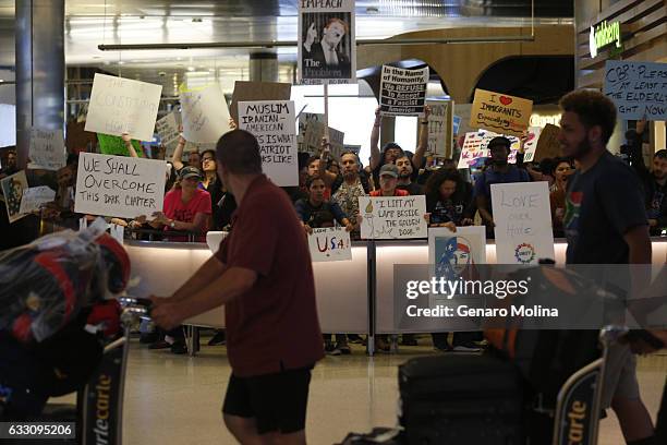 Travelers arrive while people continue to protest President Donald Trump's travel ban at the Tom Bradley International Terminal at LAX on January 29,...