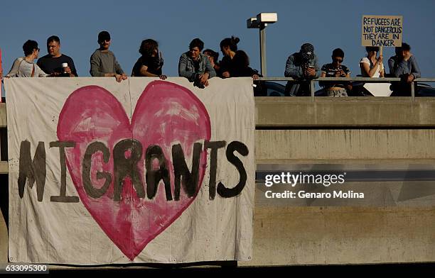 People hang a banner in support of immigrants on a parking structure across the street from the Tom Bradley International Terminal at LAX on January...