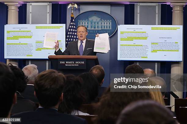 White House Press Secretary Sean Spicer holds up paperwork highlighting and comparing language about the National Security Council from the Trump...