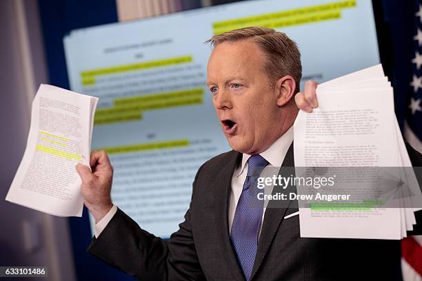 White House Press Secretary Sean Spicer holds up paperwork highlighting and comparing language about the National Security Council from the Trump...