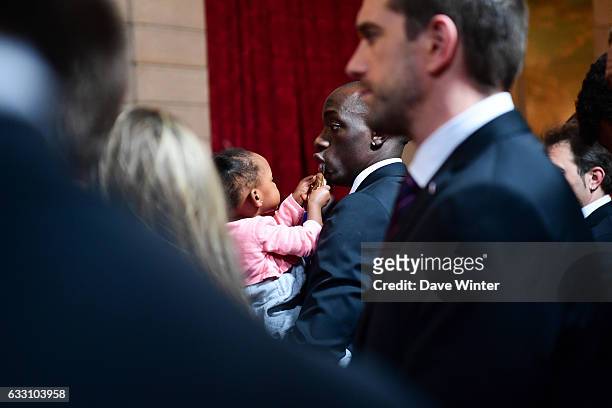 Olivier Nyokas of the France handball team, who have just won the World Championships, plays with his daughter during a reception given by French...