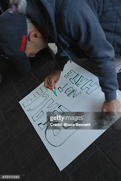 Protestor draws a sign opposing U.S. President Donald Trump's travel ban during a demonstration outside the Bradley International Terminal at LAX...