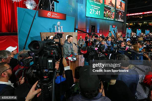 New England Patriots quarterback Tom Brady surrounded by the media as he answers questions during Super Bowl Opening Night on January 30 at Minute...