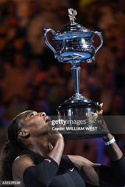 Serena Williams of the US celebrates with the championship trophy during the awards ceremony after her victory against Venus Williams of the US in...