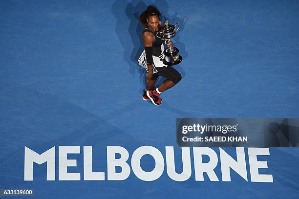 Serena Williams of the US holds the championship trophy after her victory in the women's singles final match against Venus Williams of the US on day...