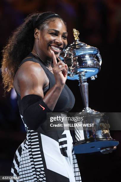 Serena Williams of the US celebrates with the championship trophy during the awards ceremony after her victory against Venus Williams of the US in...