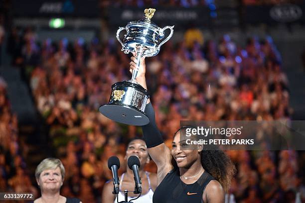 Serena Williams of the US celebrates with the championship trophy during the awards ceremony after her victory against Venus Williams of the US in...