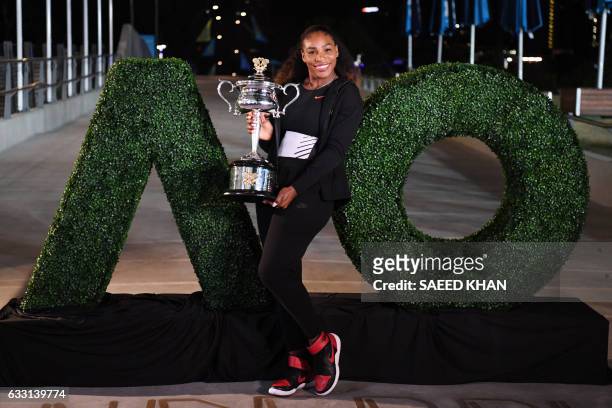 Serena Williams of the US poses with the championship trophy after her victory against Venus Williams of the US in the women's singles final on day...