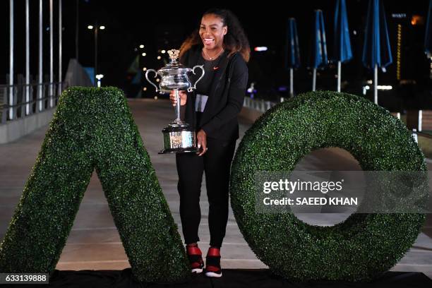 Serena Williams of the US poses with the championship trophy after her victory against Venus Williams of the US in the women's singles final on day...