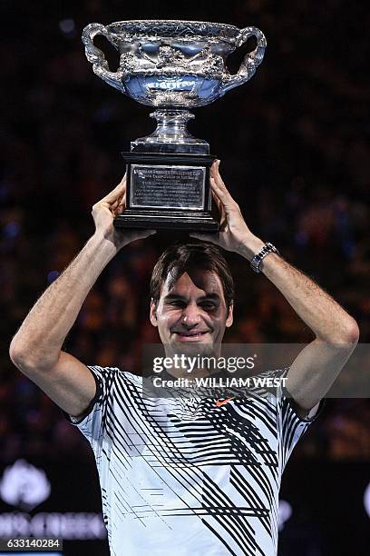 Switzerland's Roger Federer celebrates with the championship trophy during the awards ceremony after his victory against Spain's Rafael Nadal in the...