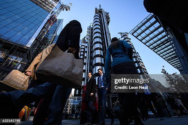 City workers walk past the Lloyds building in the financial district, also known as the Square Mile, on January 20, 2017 in London, England....