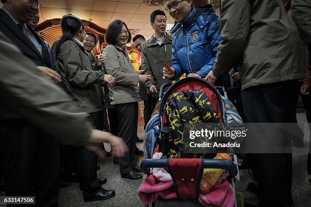 President of Taiwan Tsai Ing-wen hands out red envelopes containing NT$1 coin to visitors during a celebration blessing the new lunar Rooster year at...