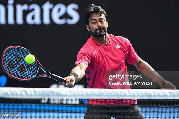 India's Leander Paes hits a return against Australia's Casey Dellacqua and Matt Reid during their mixed doubles second round match on day eight of...