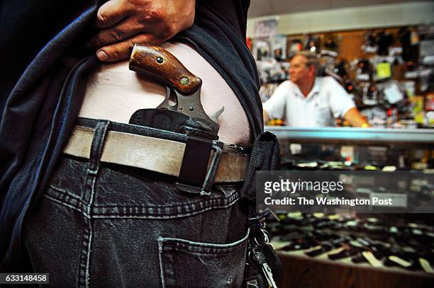Customer fits his new gun holster at Bob Moates Sport Shop on June 25, 2010 in Midlothian, Va.