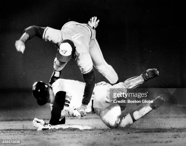 Boston Red Sox player Rich Gedman, bottom, and Toronto Blue Jay player Damaso Garcia collide during a game at Fenway Park in Boston on June 30, 1986.