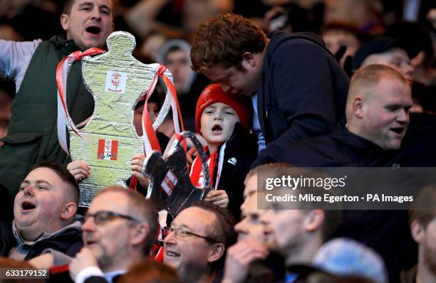 Lincoln City fan holds a cardboard trophy in the stands