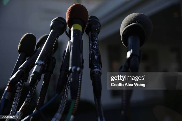 Microphones belong to different media outlets are set up on a stand in front of the West Wing of the White House January 31, 2017 in Washington, DC....