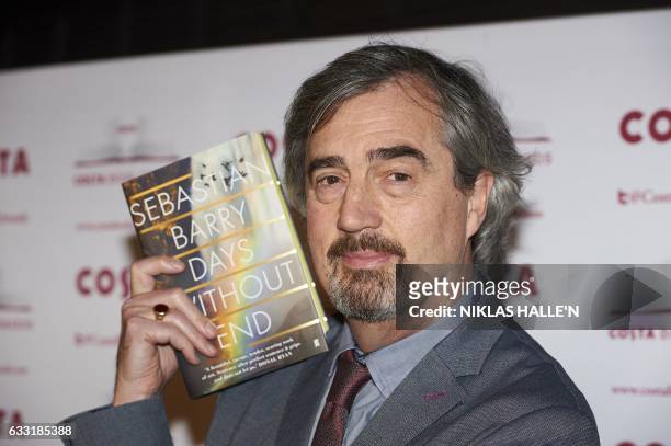 Irish author Sebastian Barry poses with his Novel Award winning book 'Days Without End' as he arrives for the 2016 Costa Book Awards in London on...