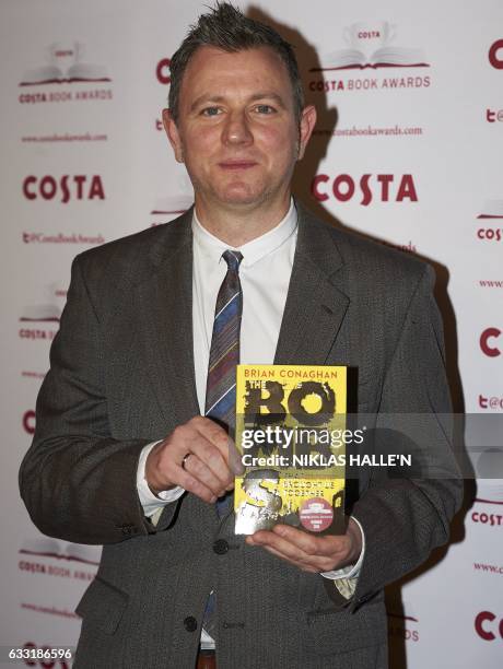 British author Brian Conaghan poses with his Children's Book Award winning book 'The Bombs That Brought Us Together' as he arrives for the 2016 Costa...