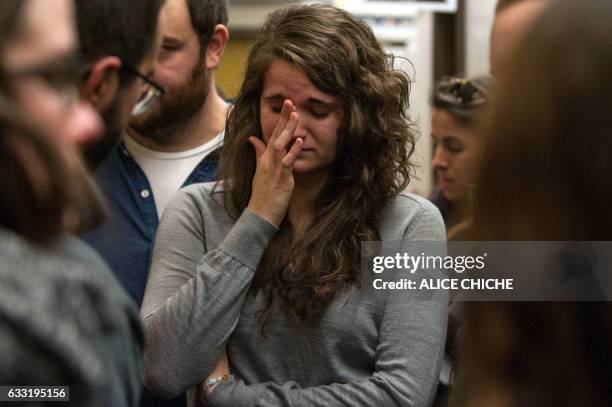 Student weeps in front of the office of her former professor, Khaled Belkacemi, one of the six shooting victims on the campus of Laval University on...