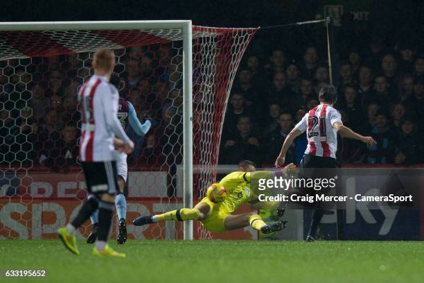 Brentford's Lasse Vibe scores the opening goal past Aston Villa's Sam Johnstone during the Sky Bet Championship match between Brentford and Aston...