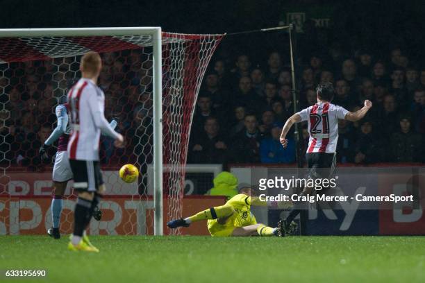 Brentford's Lasse Vibe scores the opening goal past Aston Villa's Sam Johnstone during the Sky Bet Championship match between Brentford and Aston...