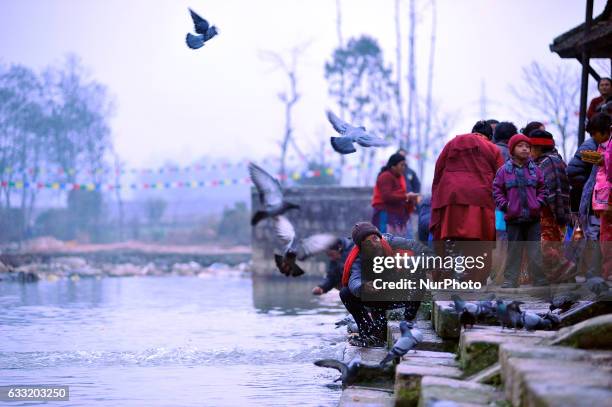 Nepalese Devotees offering holy water towards god on Triveni River during Madhav Narayan Festival or Swasthani Brata Katha festival celebrated at...