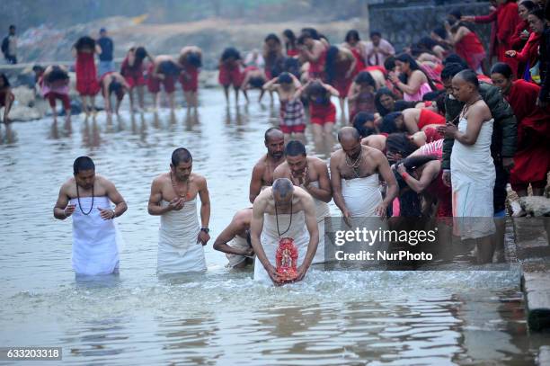 Nepalese Hindu devotees holy bathing idol Madhav Narayan in Triveni River during Madhav Narayan Festival or Swasthani Brata Katha festival celebrated...