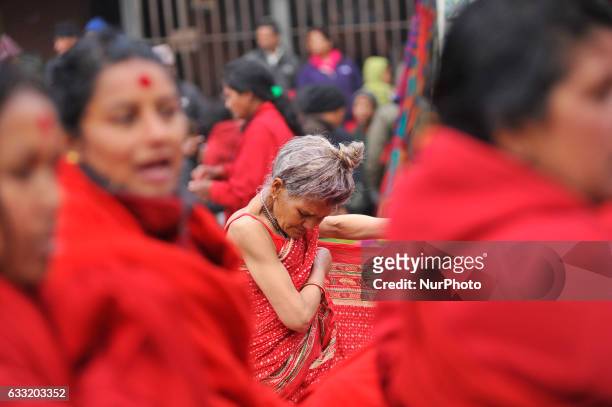 An old woman wearing clothes after taking ritual bath in Triveni River during Madhav Narayan Festival or Swasthani Brata Katha festival celebrated at...