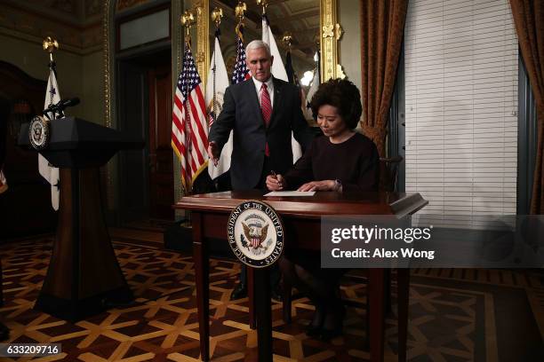 Elaine Chao signs the affidavit of appointment as U.S. Vice President Mike Pence looks on during a swearing in ceremony at the Vice President's...