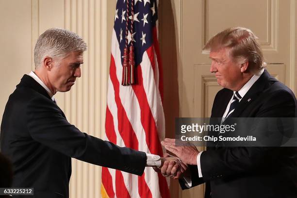 President Donald Trump shakes hands with Judge Neil Gorsuch after nominating him to the Supreme Court during a ceremony in the East Room of the White...