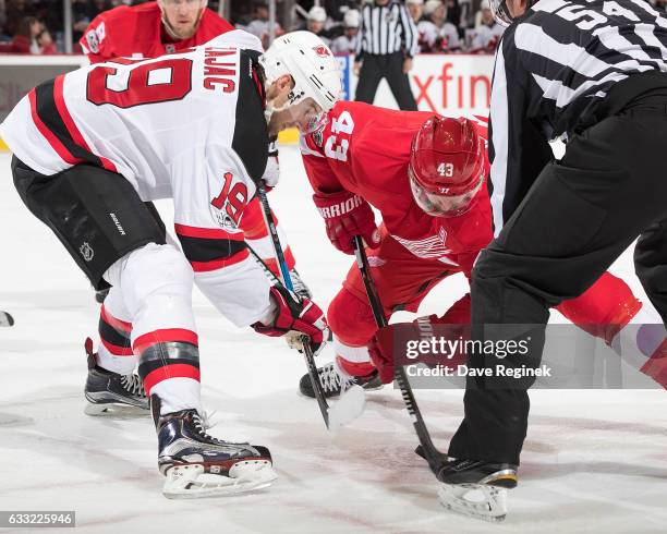 Jacob Josefson of the New Jersey Devils faces off against Darren Helm of the Detroit Red Wings during an NHL game at Joe Louis Arena on January 31,...