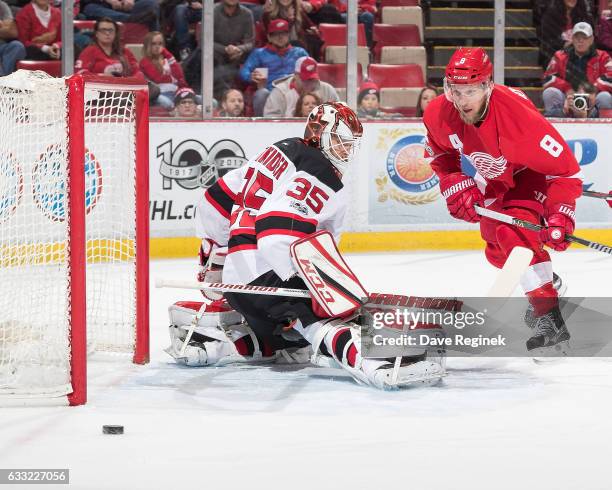 Justin Abdelkader of the Detroit Red Wings skates for a rebound as the puck is shot wide of goaltender Cory Schneider of the New Jersey Devils during...