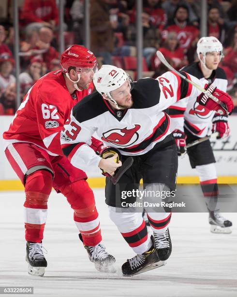 Stefan Noesen of the New Jersey Devils skates up ice followed by Thomas Vanek of the Detroit Red Wings during an NHL game at Joe Louis Arena on...