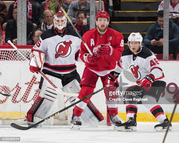 Goaltender Cory Schneider of the New Jersey Devils follows the play as teammate Karl Stollery defends against Justin Abdelkader of the Detroit Red...