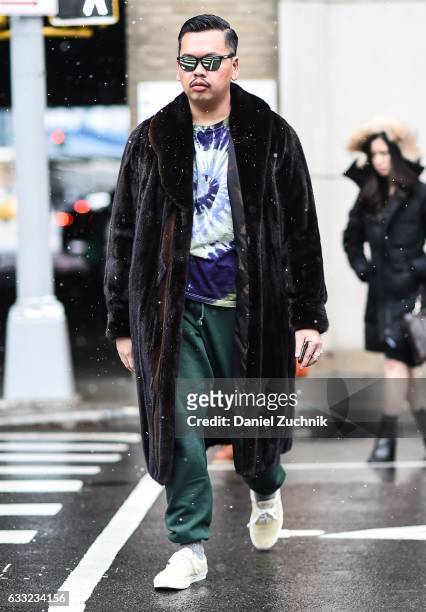 Guest is seen wearing a brown fur coat, tie dye shirt and green sweatpants outside of the Robert Geller show during New York Fashion Week: Men's AW17...