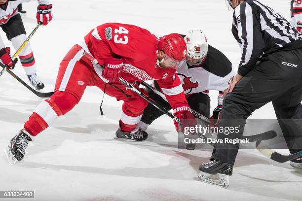 Darren Helm of the Detroit Red Wings faces off against Vernon Fiddler of the New Jersey Devils during an NHL game at Joe Louis Arena on January 31,...