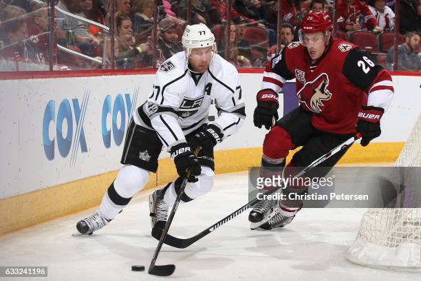 Jeff Carter of the Los Angeles Kings skates with the puck ahead of Michael Stone of the Arizona Coyotes during the third period of the NHL game at...