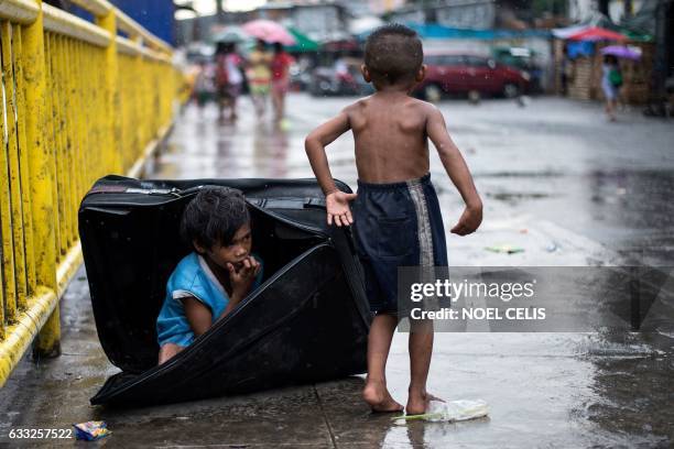 Boy hides in a suitcase at the Divisoria market in Manila on February 1, 2017. / AFP PHOTO / NOEL CELIS