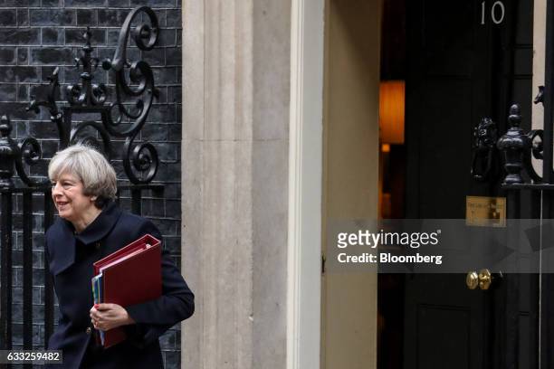 Theresa May, U.K. Prime minister, carries a document folder as she leaves 10 Downing Street to attend the weekly question-and-answer session in...