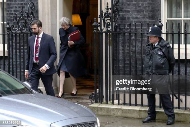 Theresa May, U.K. Prime minister, carries a document folder as she leaves 10 Downing Street to attend the weekly question-and-answer session in...