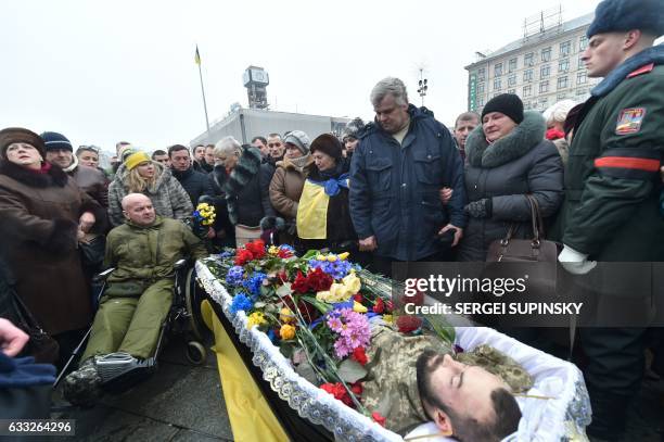 Relatives of one of the seven Ukrainian servicemen who died during fighting in eastern Ukrainian town of Avdiivka, in Donetsk region, react next to...