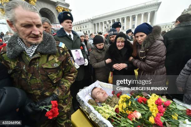 Relatives of one of the seven Ukrainian servicemen who died during fighting in eastern Ukrainian town of Avdiivka, in Donetsk region, react next to...