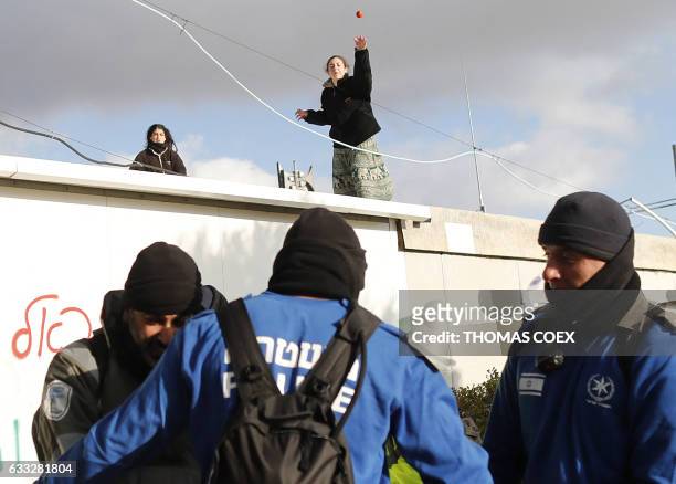 Hardline Jewish settlers, supporter of the Amona outpost, northeast of Ramallah, throws a fruit at Israeli security forces as they move away others...
